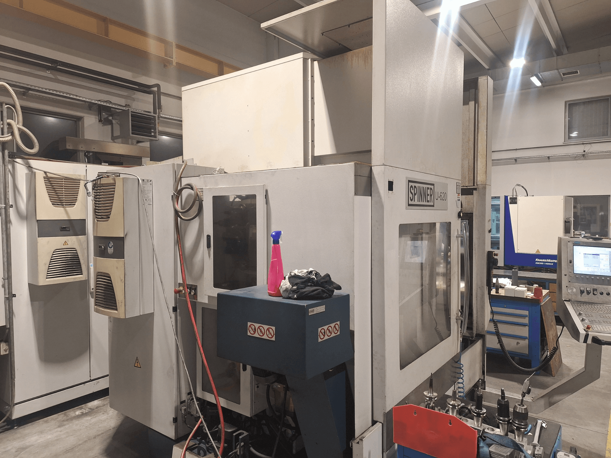 Spinner U-620 CNC-gép szemből, műhelyben, a műhelyben, a vezérlőpanel és a különböző szerszámok a közeli munkapadon.