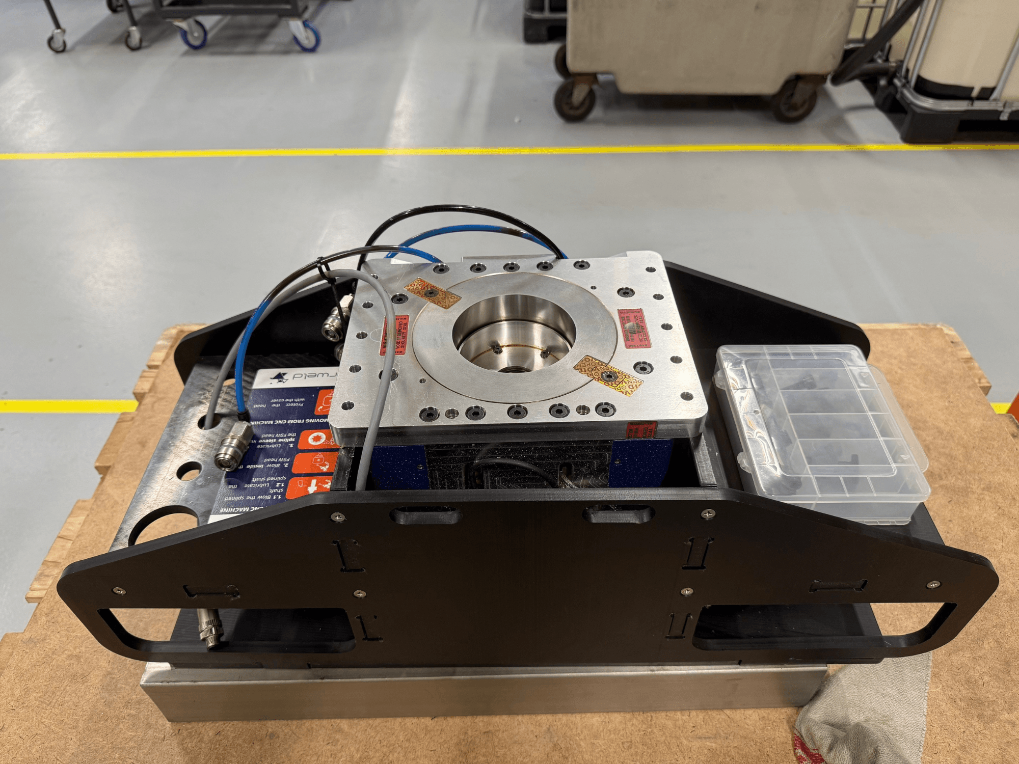 Megmunkált fém alkatrész kék kábelekkel, tartozék tokkal és lapos talppal, felülnézetből ábrázolva, ideális mechanikai alkalmazásokhoz.