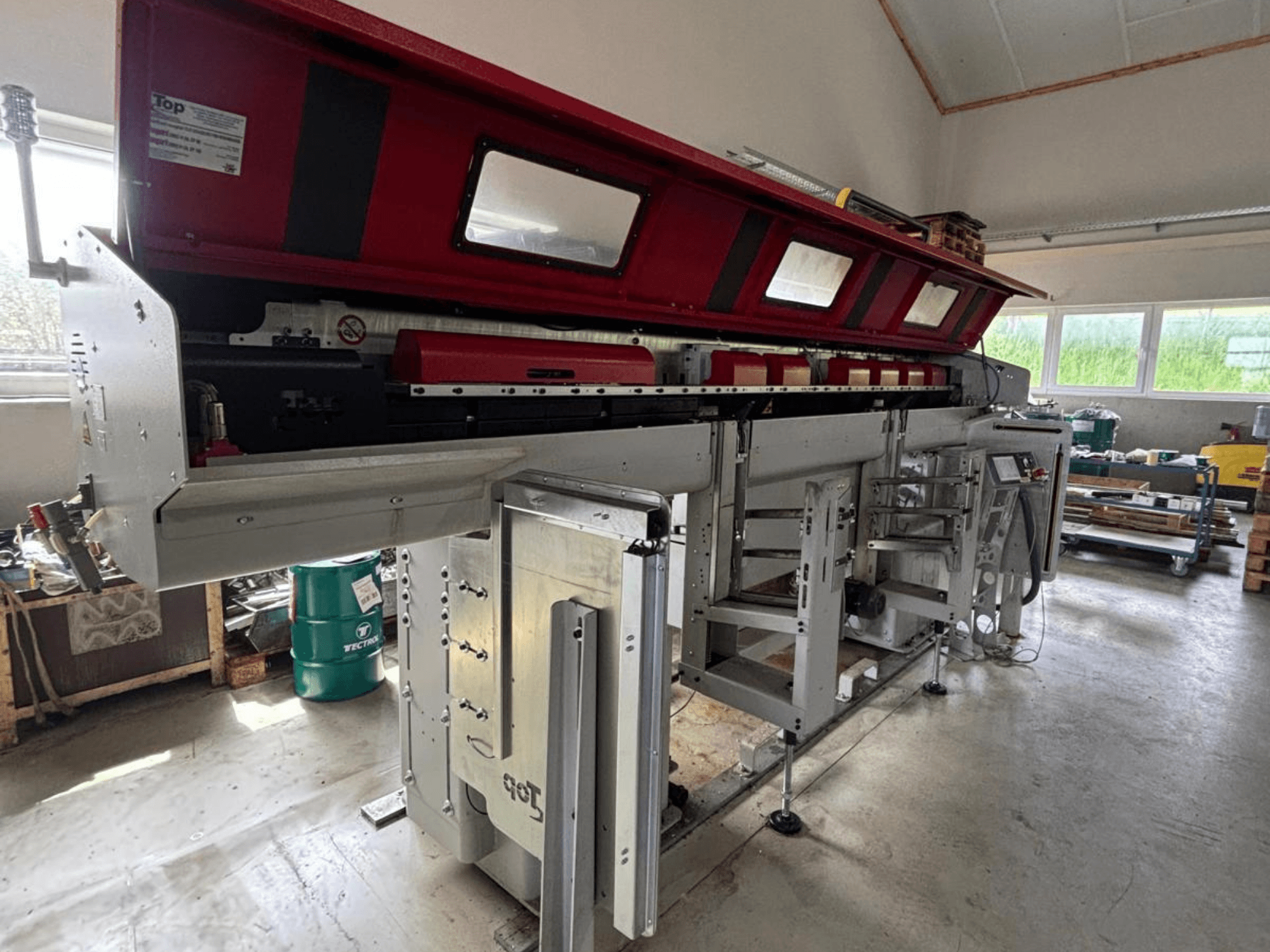 A TOP Automazioni Top Loader ETL 10-75 oldalnézetben, piros felső résszel és bonyolult mechanikai alkatrészekkel.