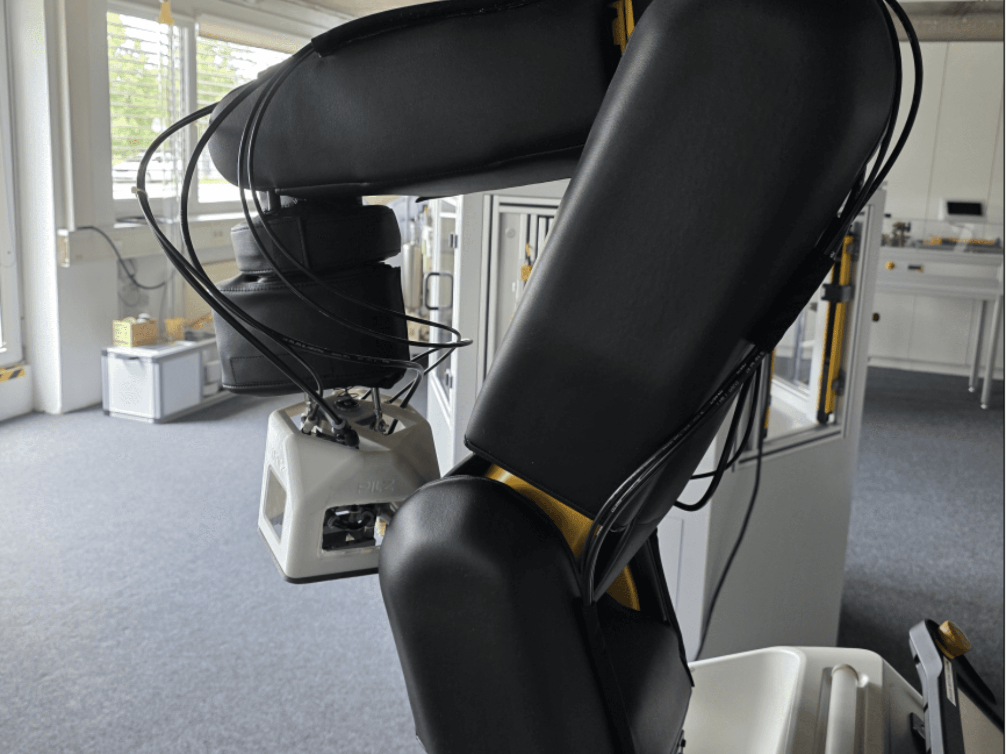 A FANUC LR Mate 200iD/7L együttműködő robot oldalnézete, amelyen látható a kar és az érzékelők, valamint a műhelyi környezetben látható kábelek.