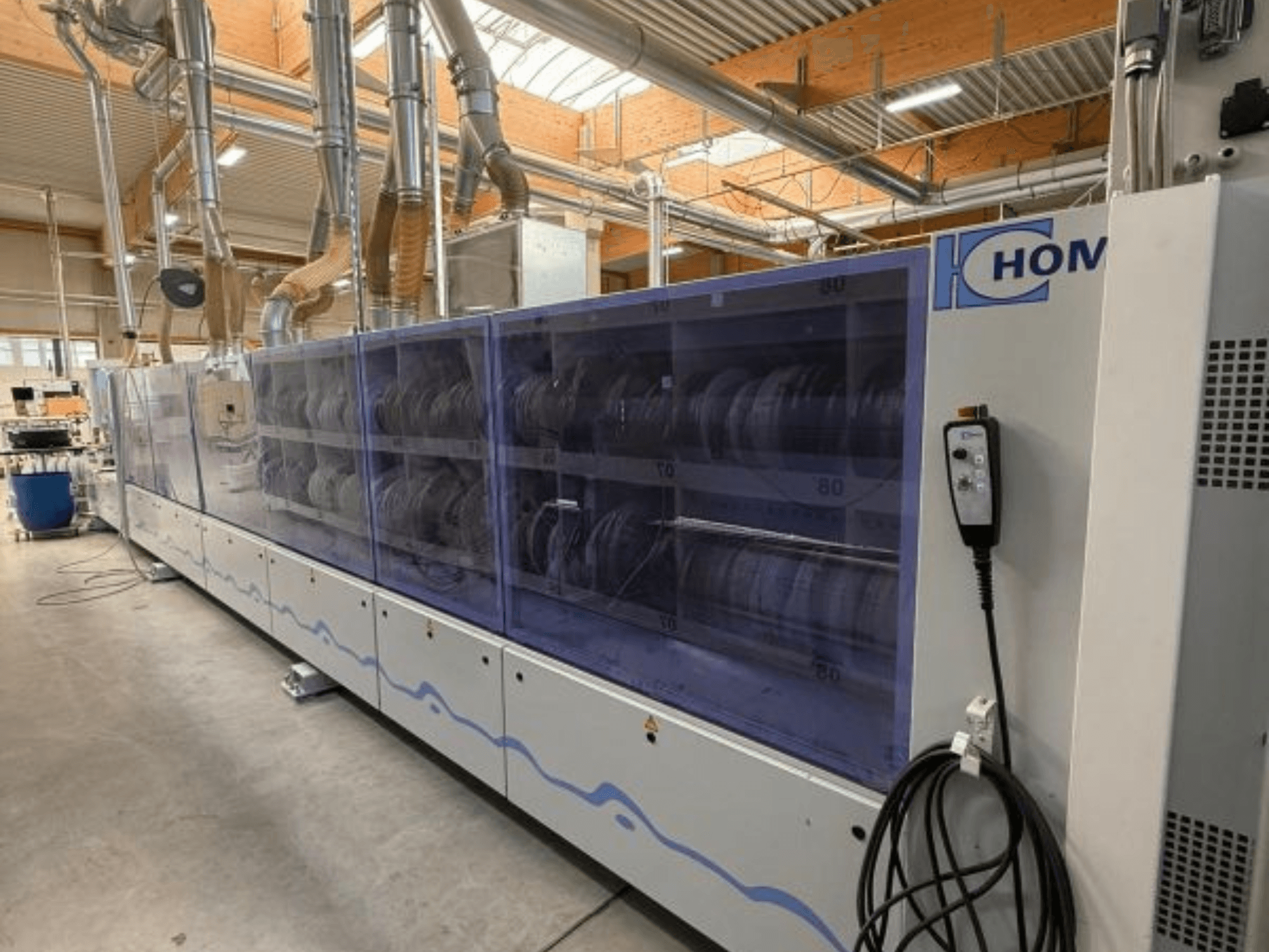 HOM ipari mosógép, elölnézetben, átlátszó panellel, amelyen az edények láthatók; vezérlőpanel gombokkal az oldalán.