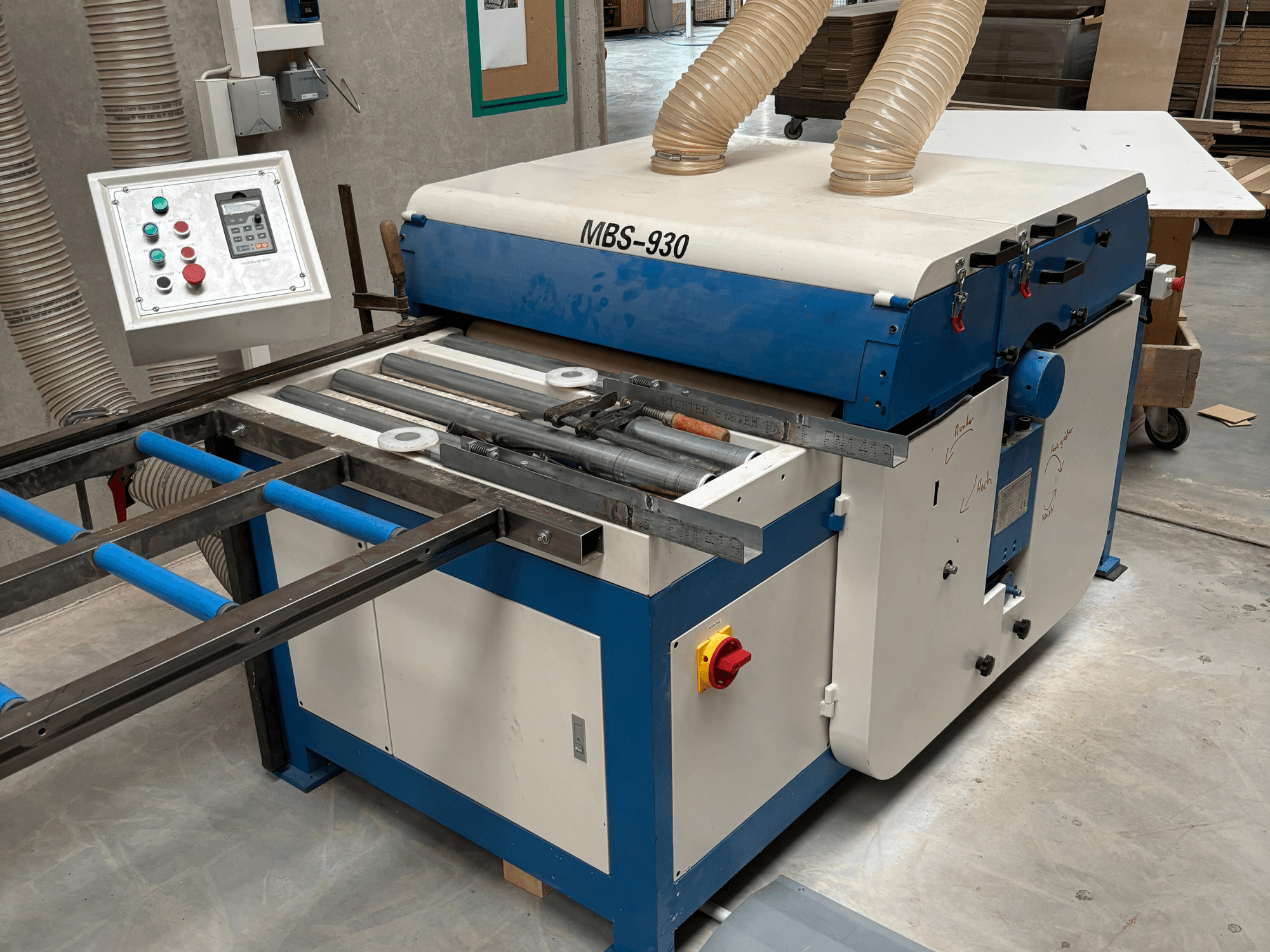 MBS-930 famegmunkáló gép vezérlőpanellel és görgőkkel, oldalnézetből, porelszívó tömlőkkel.