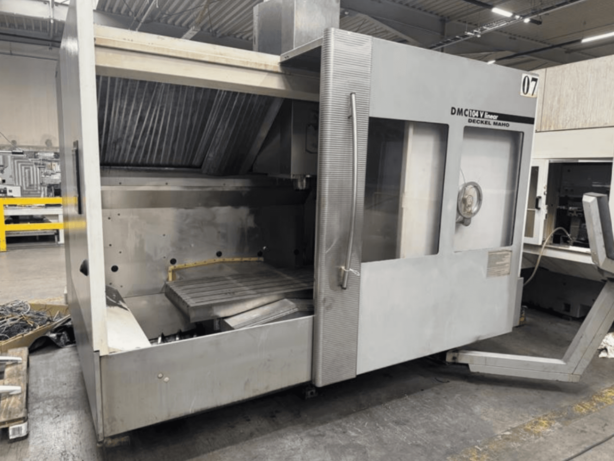 DMC 104 V lineáris gép a Deckel Maho cégtől, elölnézetben, üres megmunkálótérrel és nagy munkaasztallal.