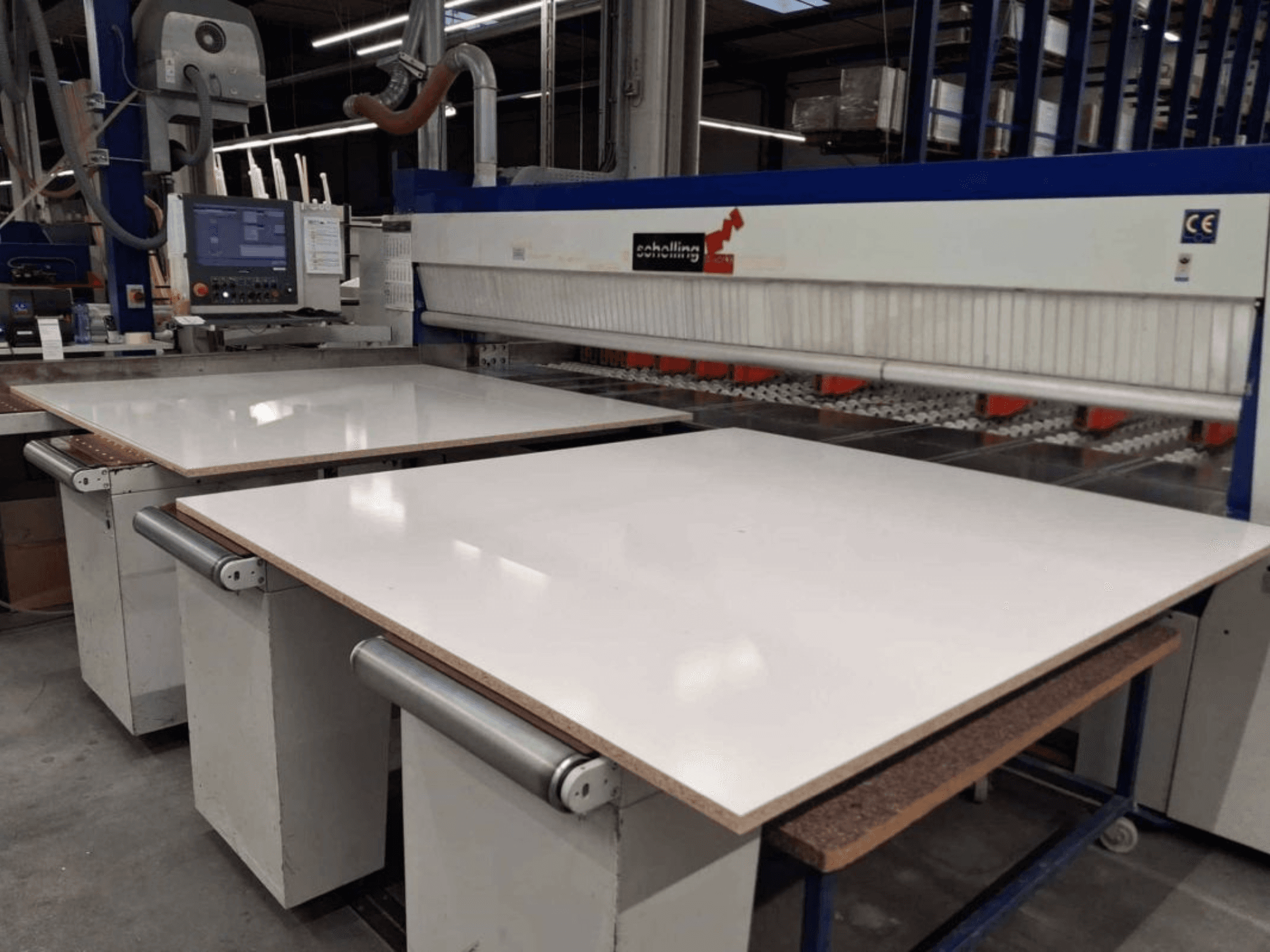 A SCHELLING FM-H 430 lemezfűrész elülső nézete, látható a fehér vágóasztal, a vezérlőpanel és a fűrészlap területe.