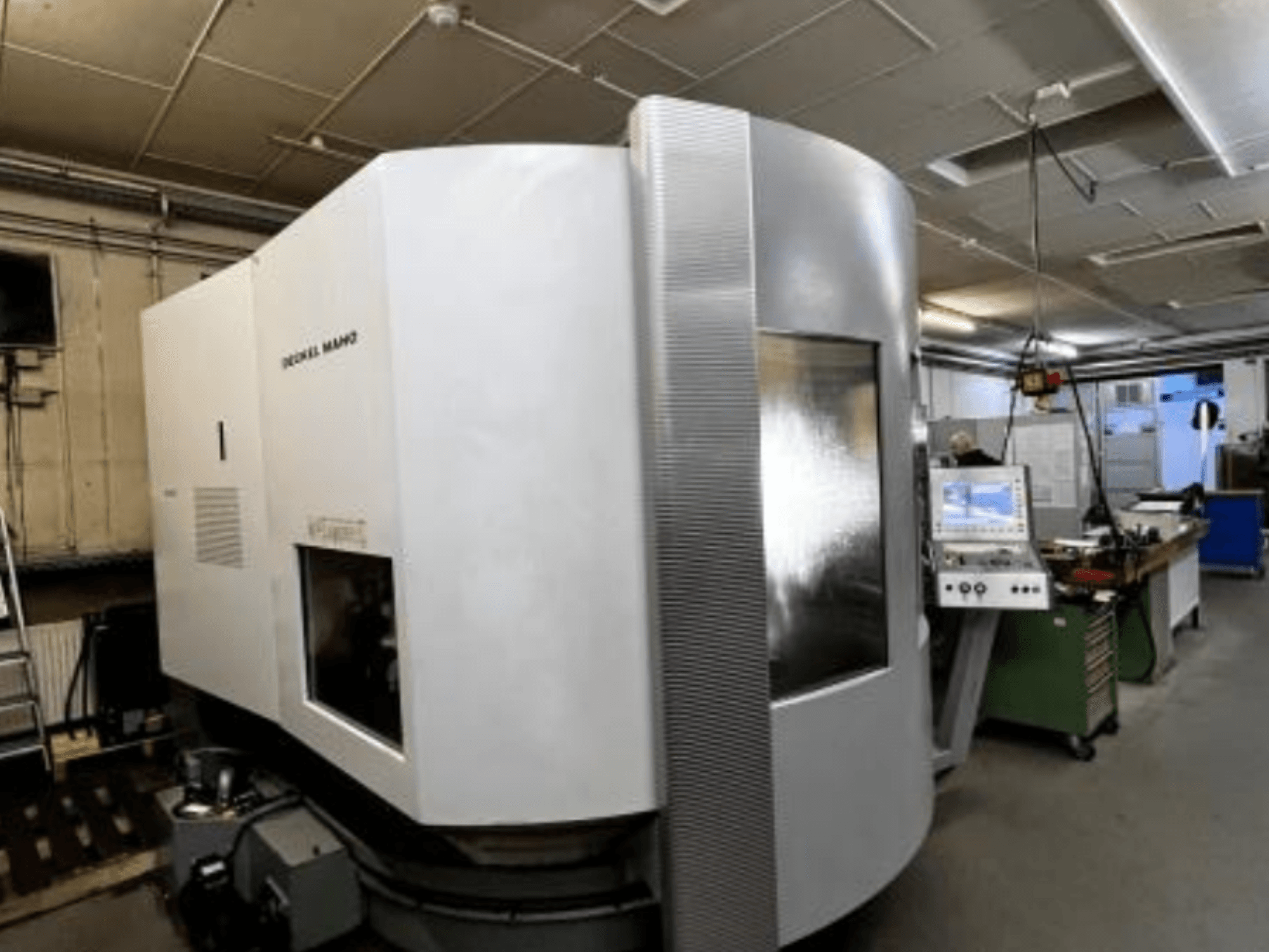 SODICK MAKO CNC-gép egy műhelyben, oldalnézet, a háttérben a vezérlőpanel és a munkaterület látható.