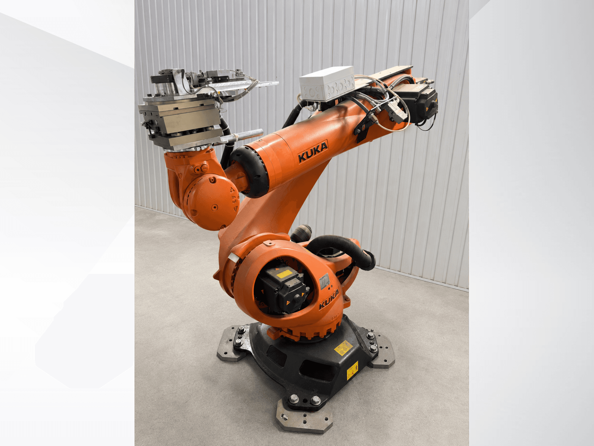 KUKA KR 90 R3100 extra robotkar narancssárga színben, oldalnézetből, az ízületek, a vezérlőegység és a véghatáson elhelyezett szerszámrögzítés bemutatásával.