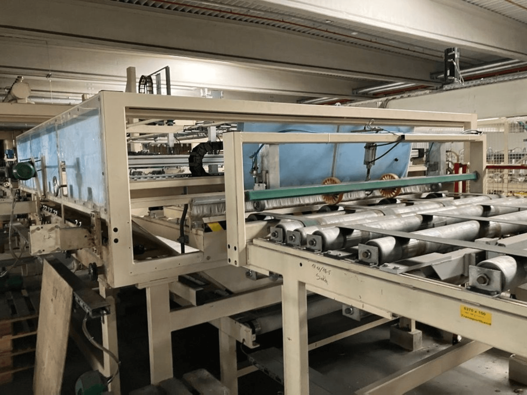 WEMHÖNER KT-F-1E laminálóprés, oldalnézet, görgőkkel és vezérléssel az üzemi anyagfeldolgozáshoz.