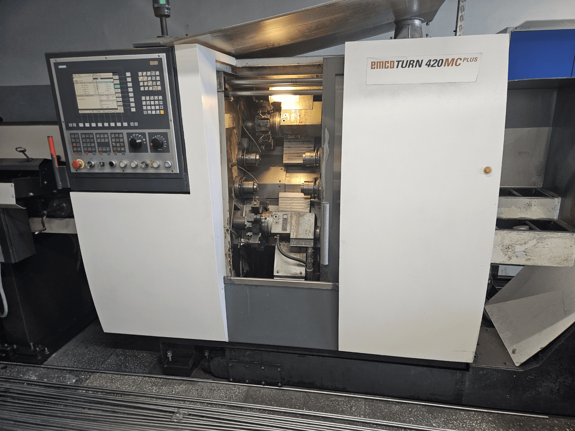 EMCO TURN 420 MC Plus többorsós gép, elölnézetben a vezérlőpanel és a belső alkatrészek.