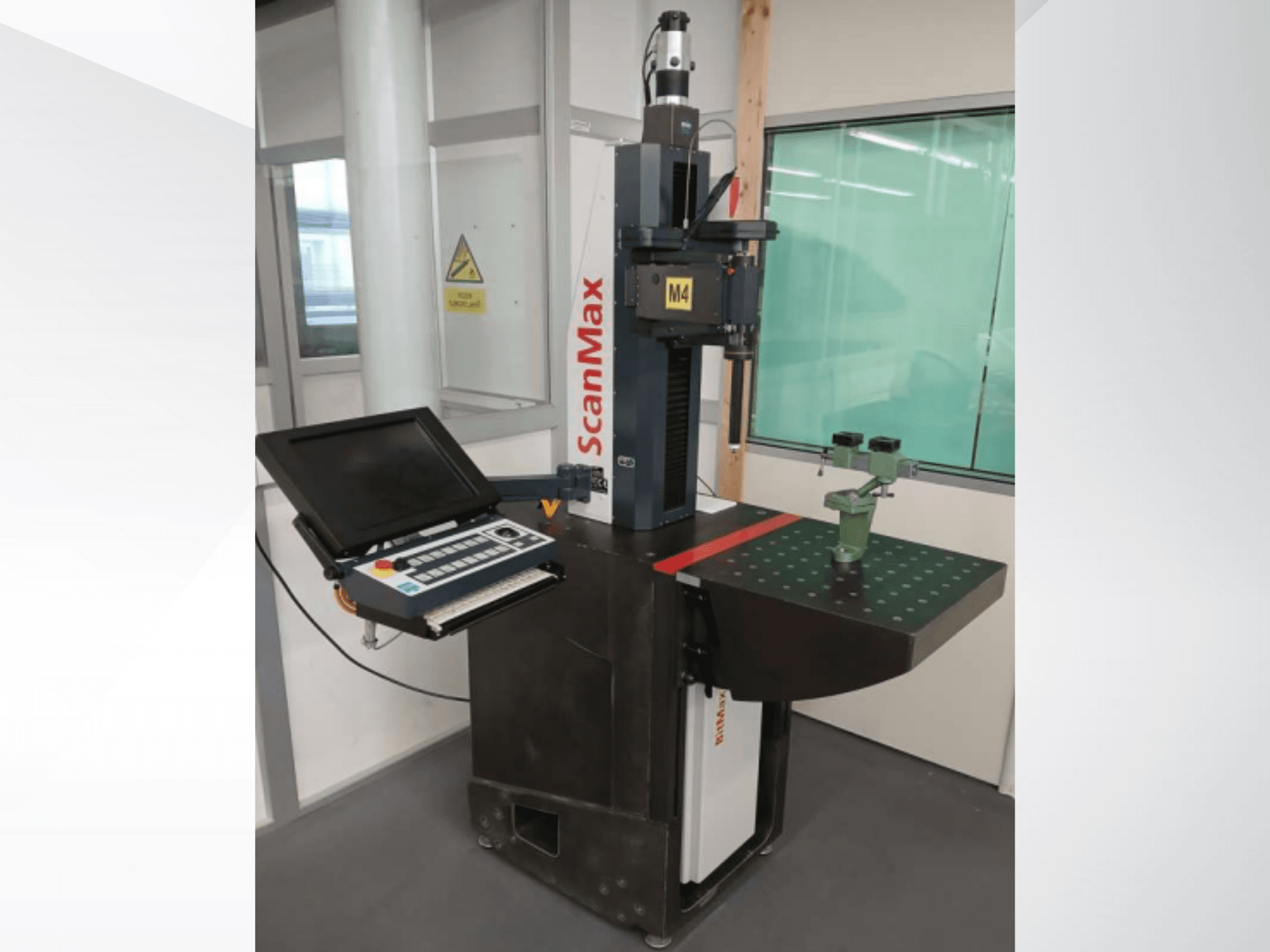 ScanMax M4 mérőgép, előlnézet a vezérlőpanellel és a zöld kalibráló rögzítővel a pontozott munkaasztalon.