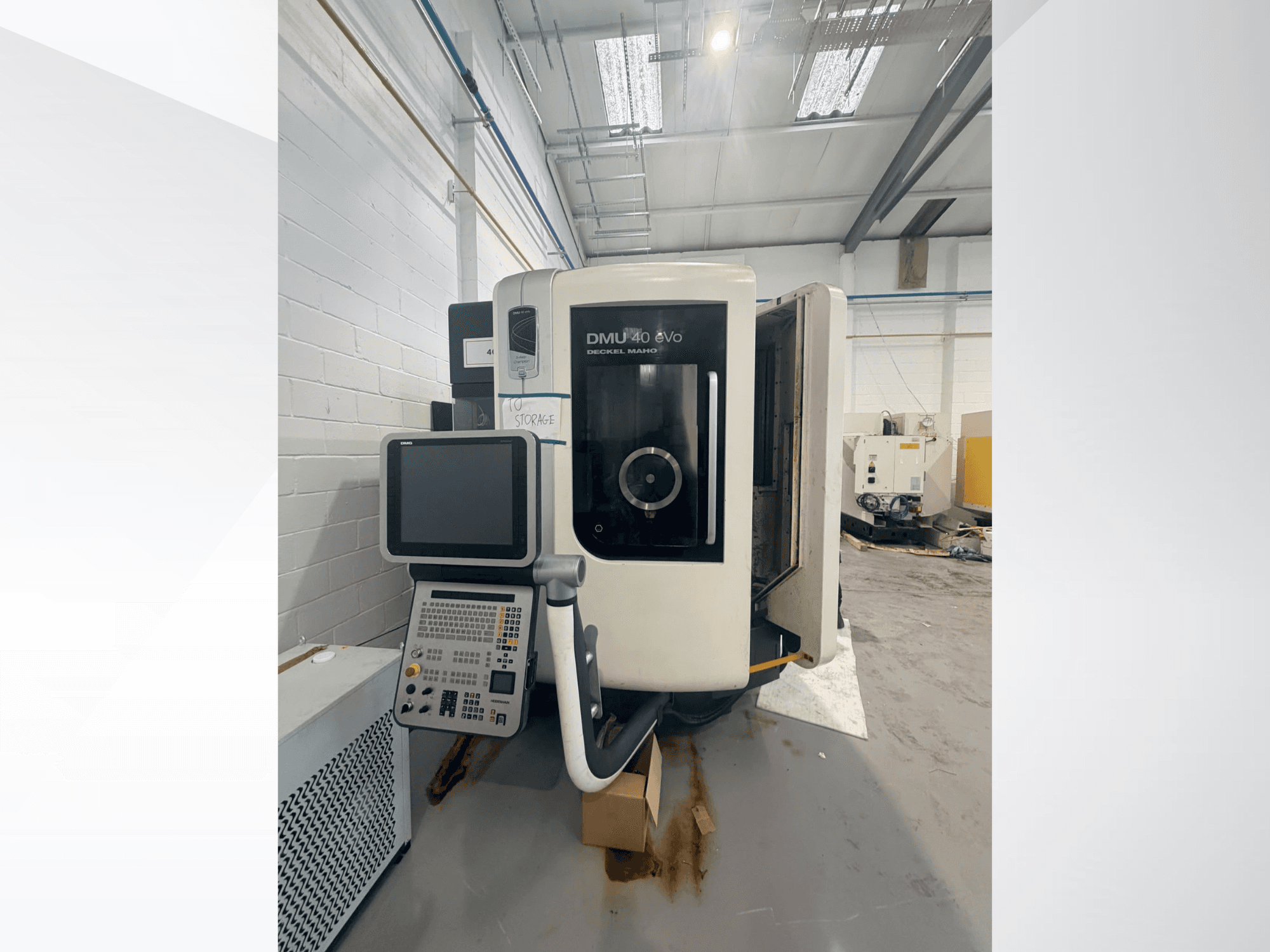 A DMG DMU 40 evo függőleges megmunkálóközpont elölnézete, amelyen látható a vezérlőpanel és az orsóterület, a háttérben a munkaterülettel.