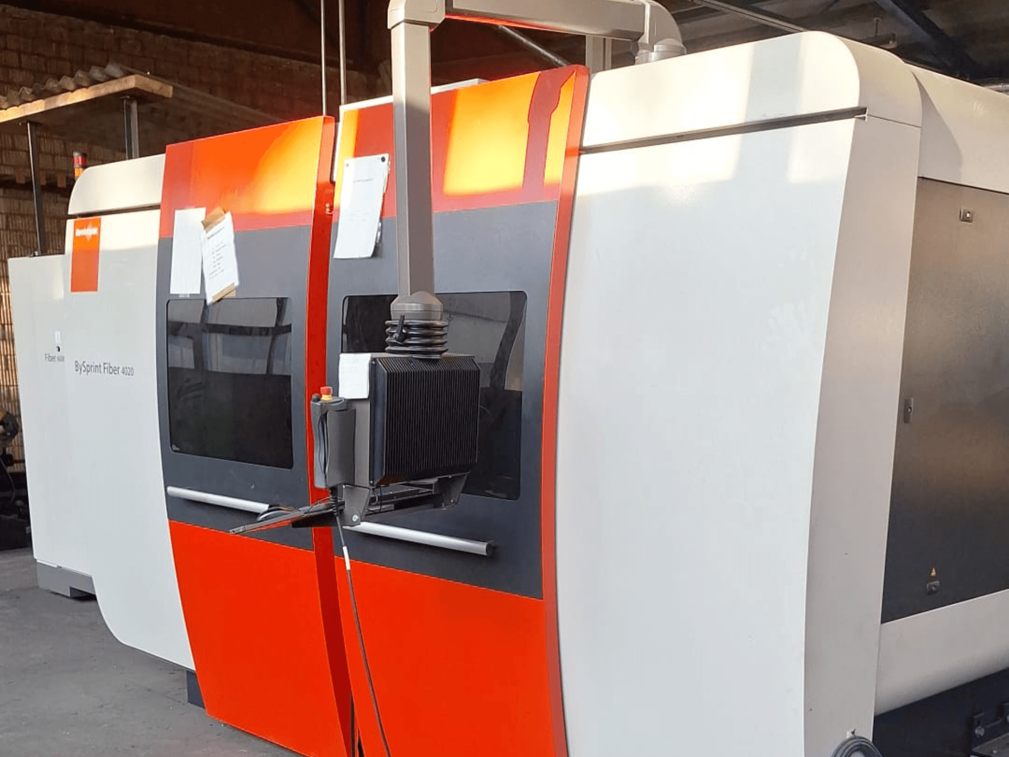 BySprint Fiber 4020 lézervágógép, oldalnézet, piros-fehér külsővel, részletes vezérlőpanel látható.