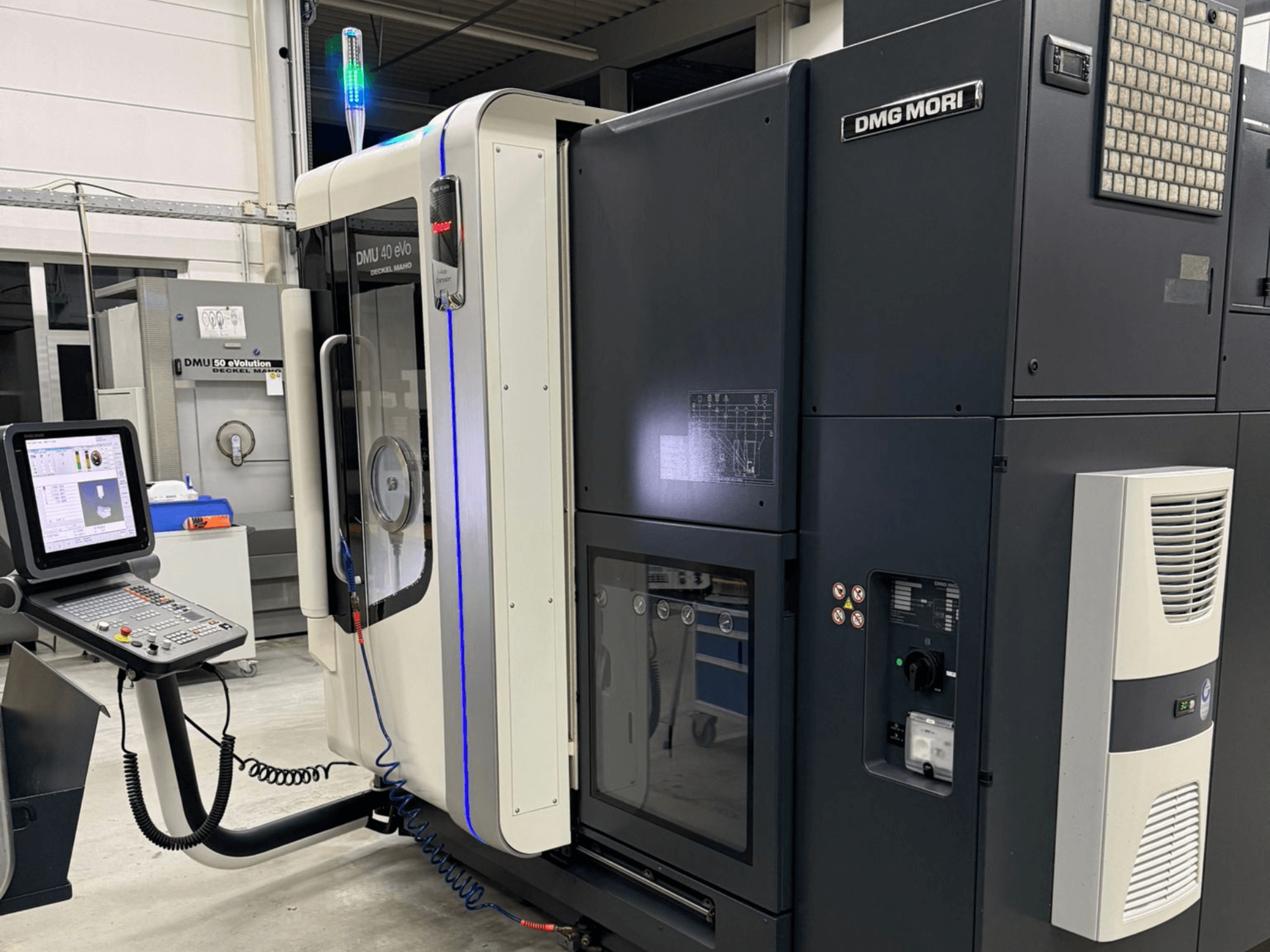 DMG MORI DMU 40 eVo gép, elölnézetben a kezelőszervek, a LED-es kijelzők és az ipari jellemzőket hangsúlyozó elegáns kialakítás.
