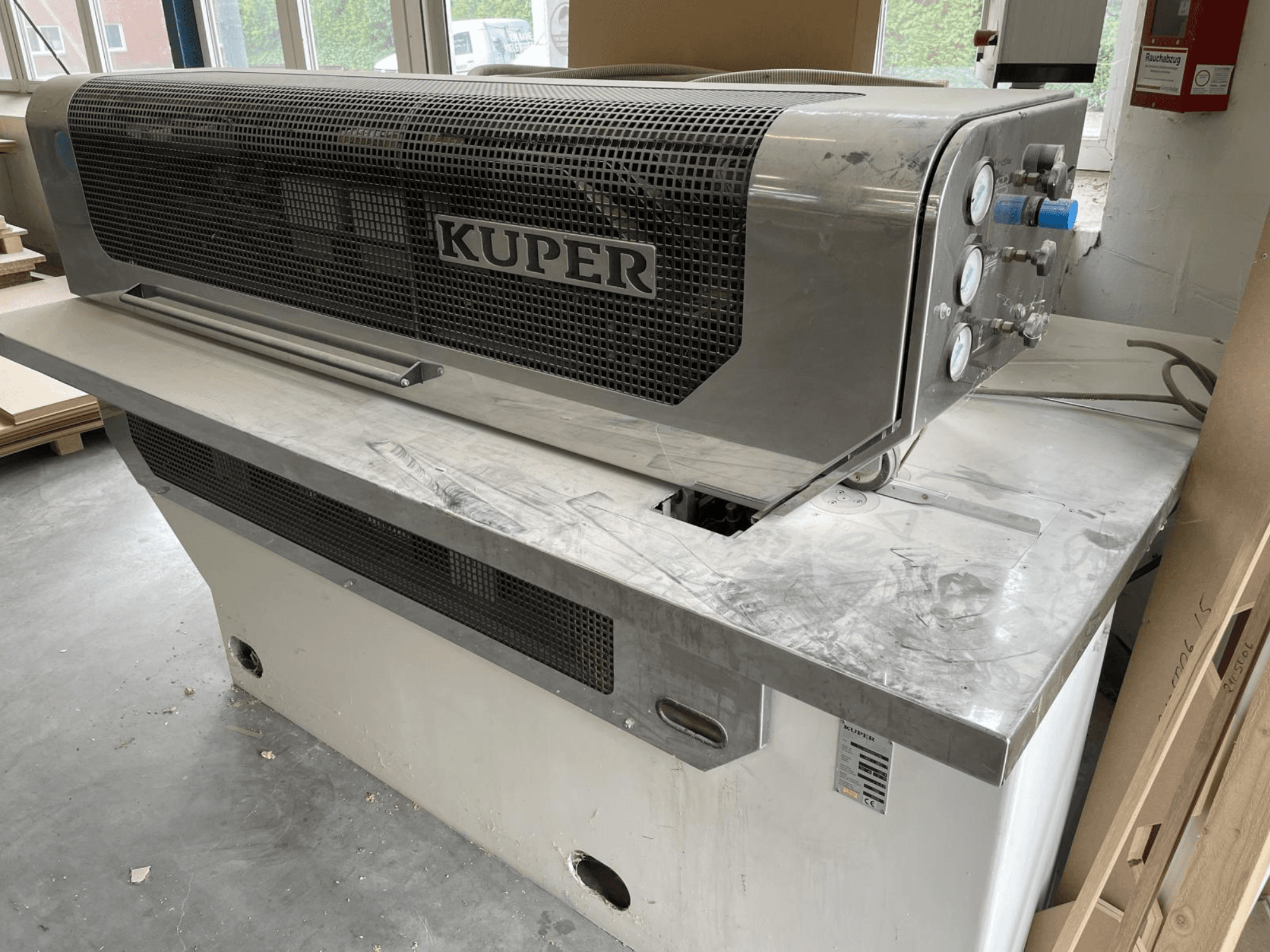 Furnér guillotine KUPER FLI, elölnézet, rozsdamentes acél testtel, műszerekkel és tiszta vágási területtel a munkapadon.