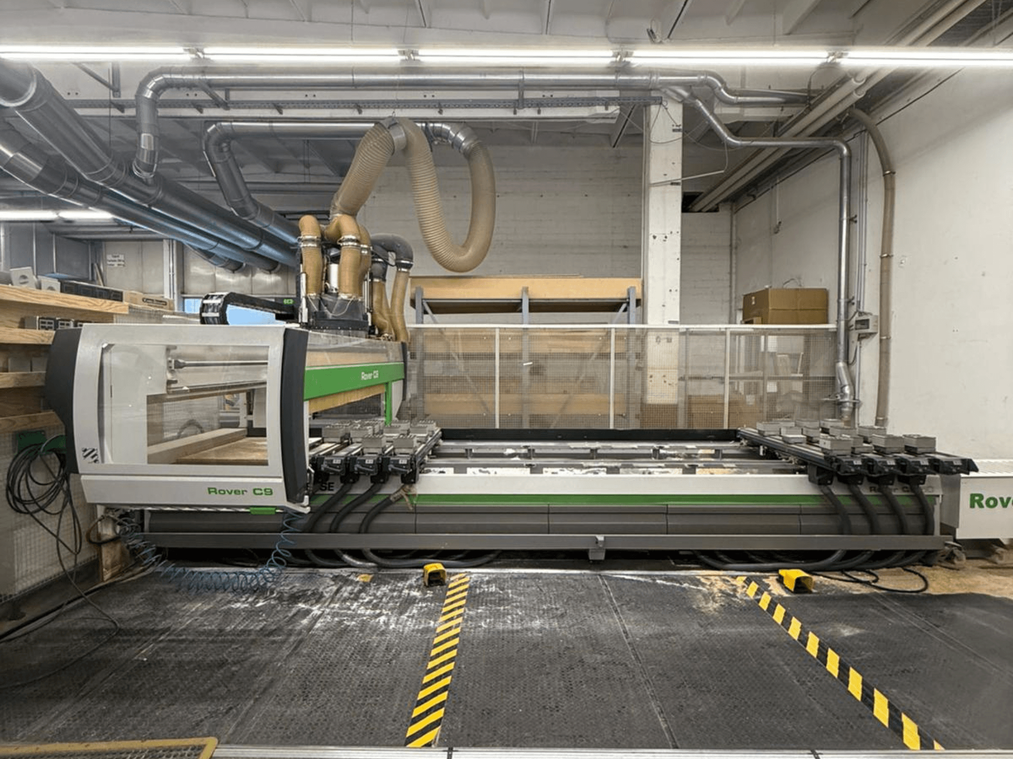 Rover C9 CNC-gép egy műhelyben, elölnézetben, több vágófejjel és látható porelszívó rendszerrel.
