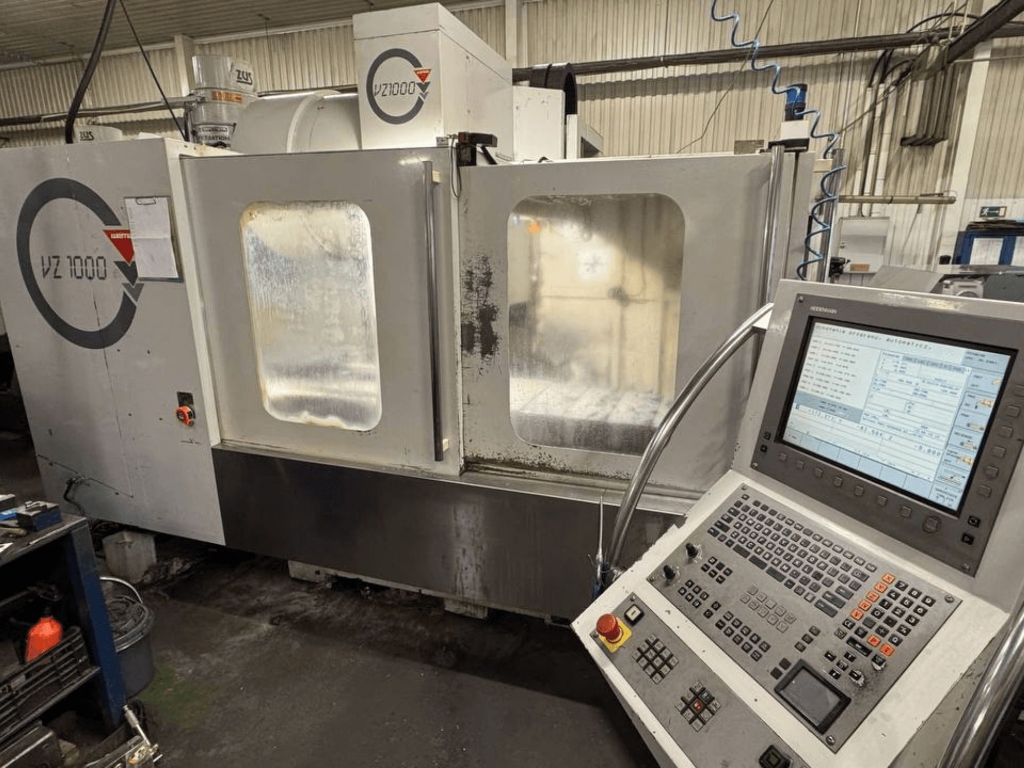 A WEMAS VZ 1000 függőleges megmunkálóközpont előlapja, vezérlőpanellel és átlátszó hozzáférési ajtókkal.