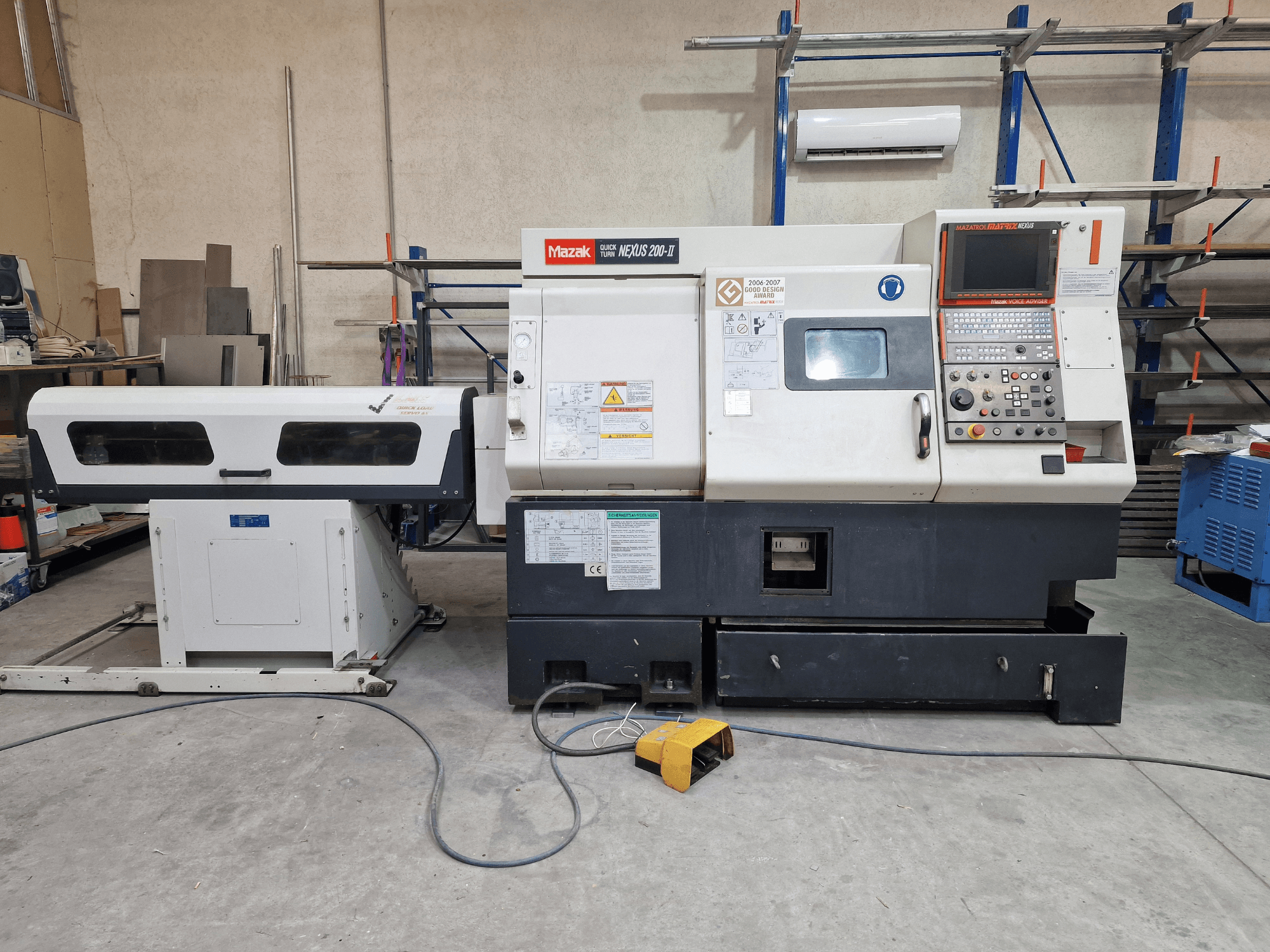 Mazak QuickTurn Nexus 200 vízszintes eszterga, oldalnézet, amelyen látható a kezelőpanel, az orsó és a forgácstálca.