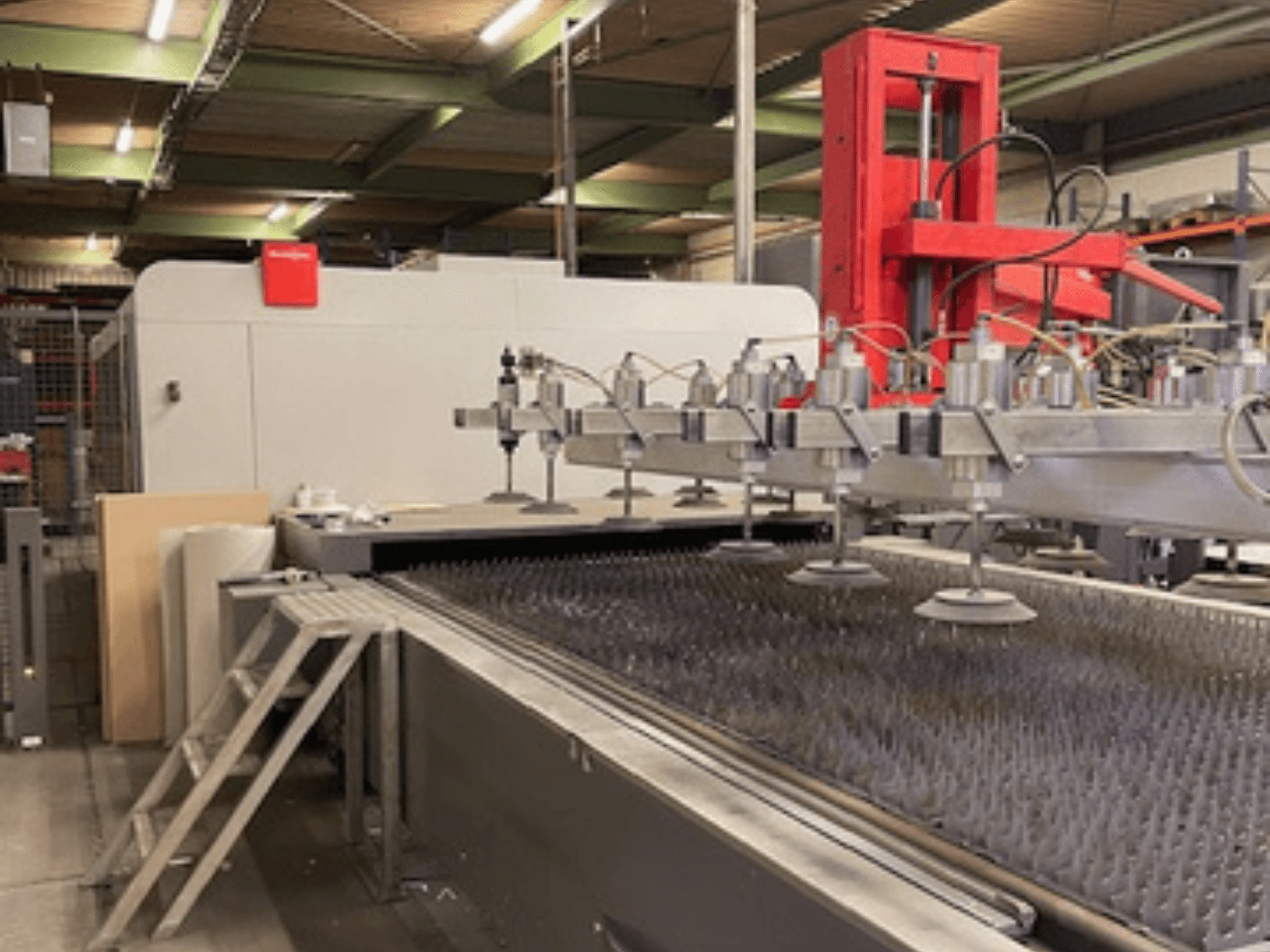 Bystronic BySprint Fiber 4020 Fiber 4Kw egy szálas lézervágógép előlapja fúvókákkal és vágóágyakkal.