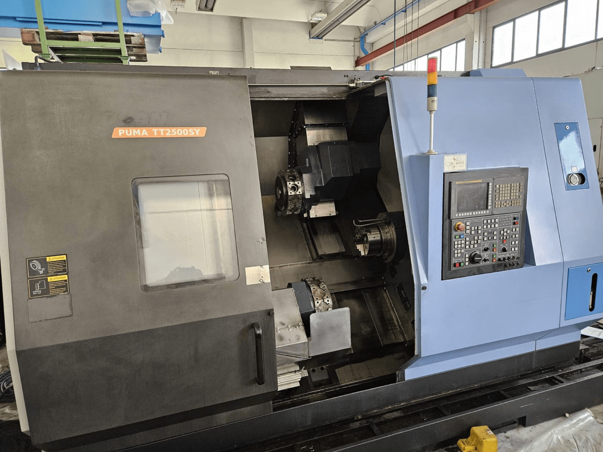 DOOSAN PUMA TT2500SY többorsós eszterga, elölnézet, amelyen látható a vezérlőpanel és a gép belső részletei.