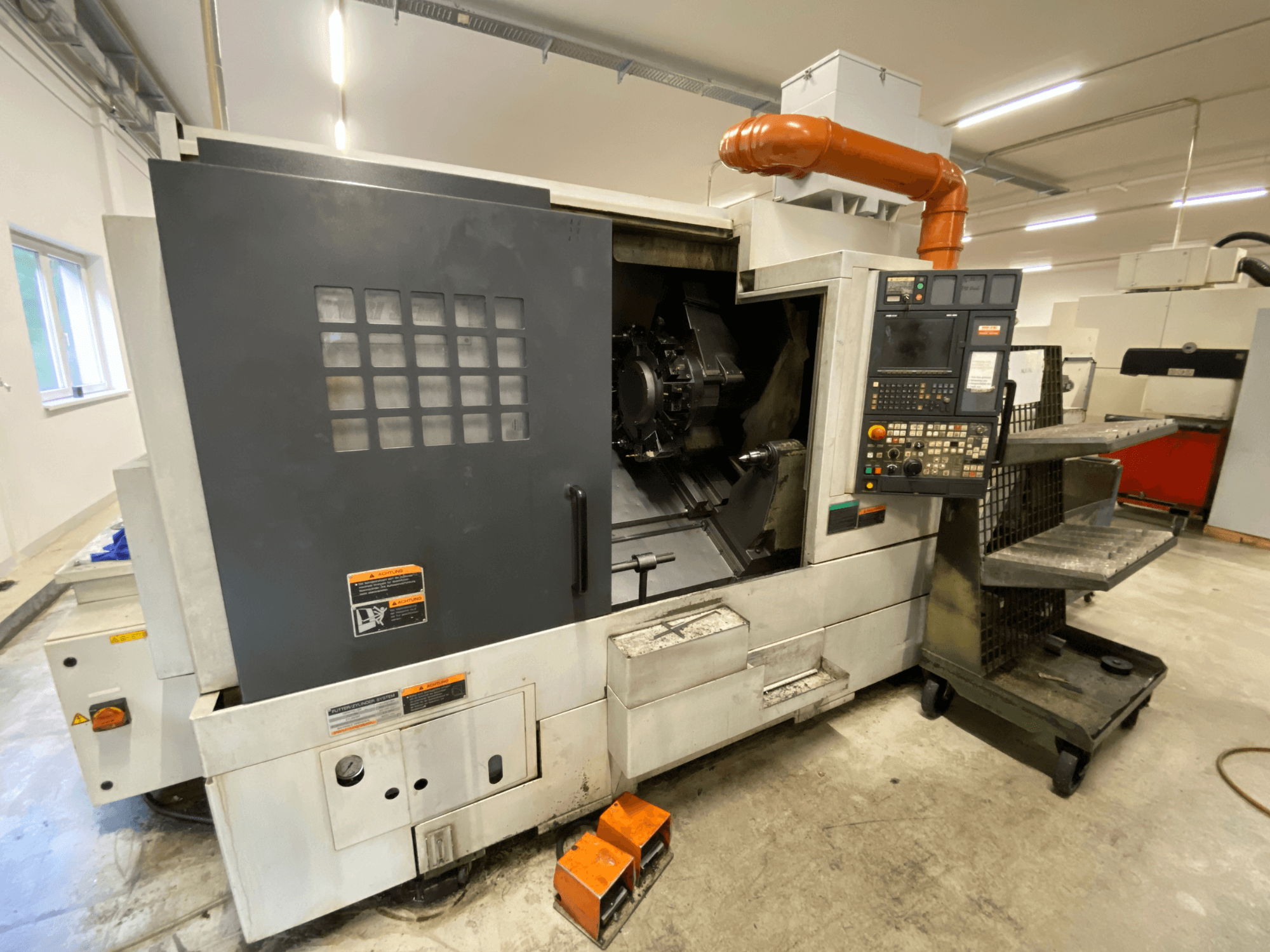 DMG Mori Seiki NL2500Y/700 eszterga-marógép, elölnézet a vezérlőpanellel és a gép burkolatának részleteivel.