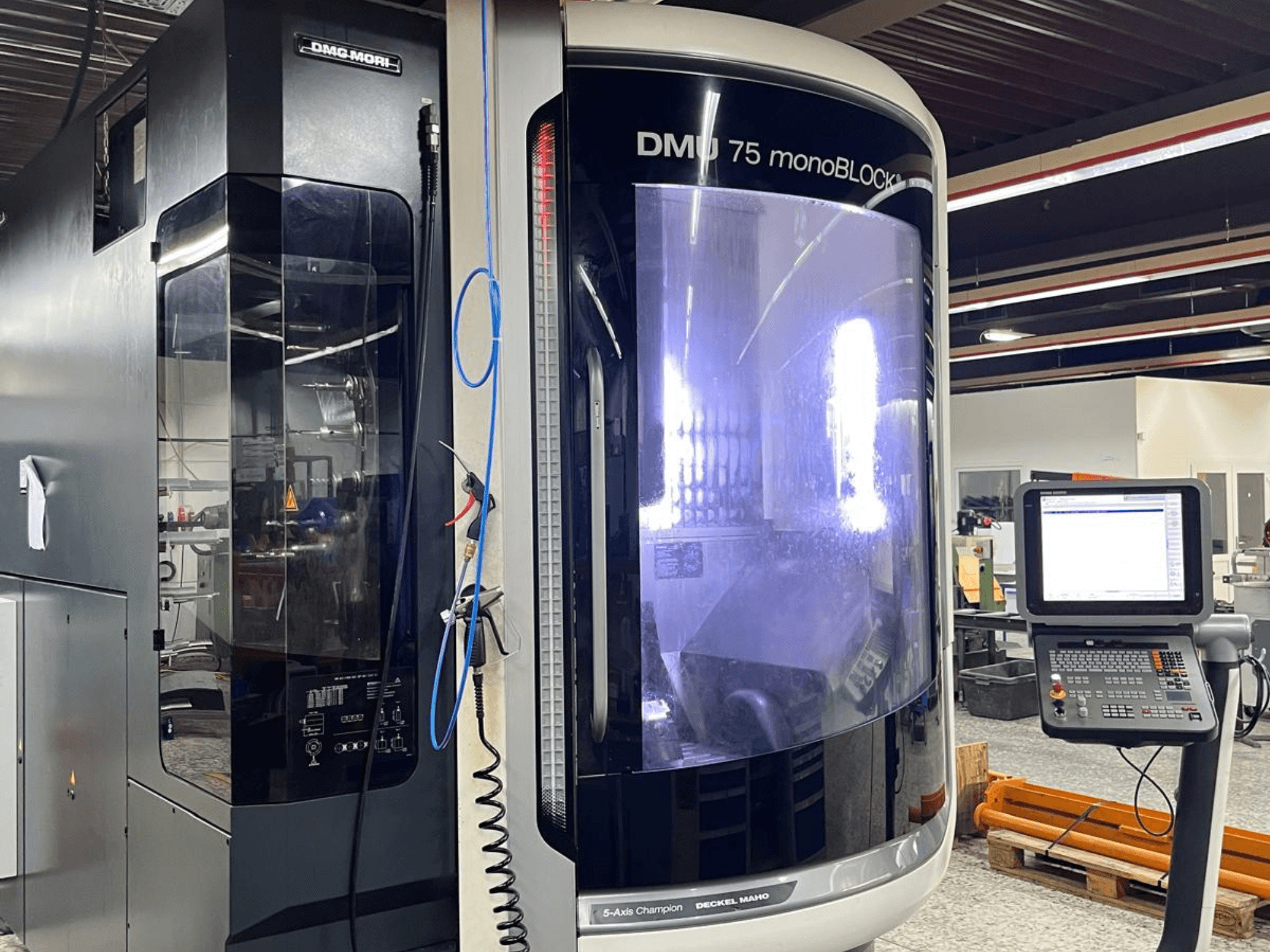 DMG MORI DMU 75 MonoBlock univerzális megmunkálóközpont, előlnézet, a vezérlőpanel és a jellegzetes burkolat megjelenítése.