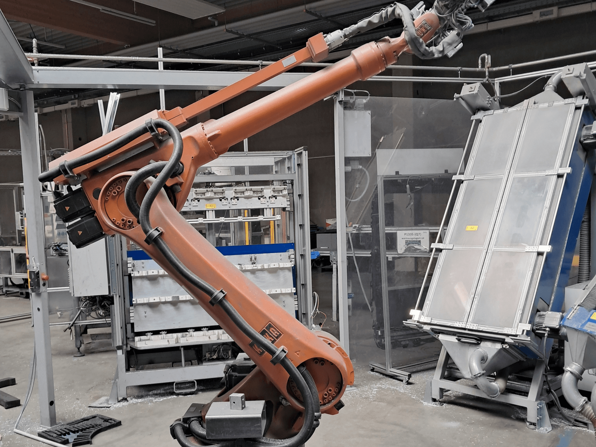 KUKA KR 30L16-2 robotkar gyári környezetben, oldalnézetből, a kábelekkel és a mechanikus alkatrészekkel együtt.