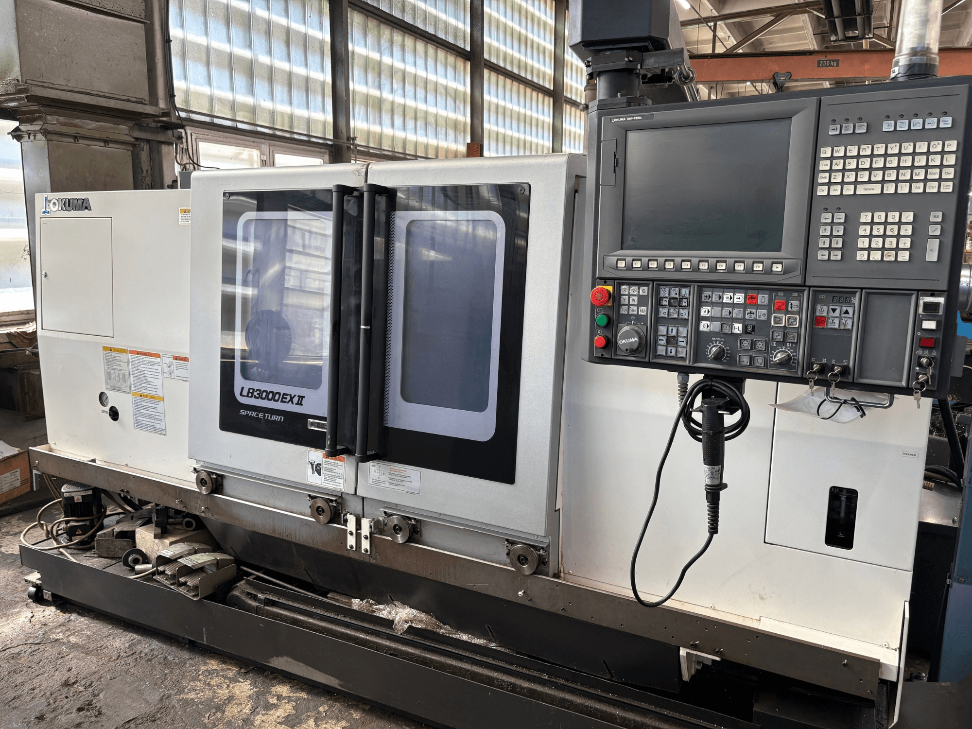 Okuma LB3000EXII vízszintes eszterga, elölnézet, amelyen látható a vezérlőpanel és a betöltőajtó.