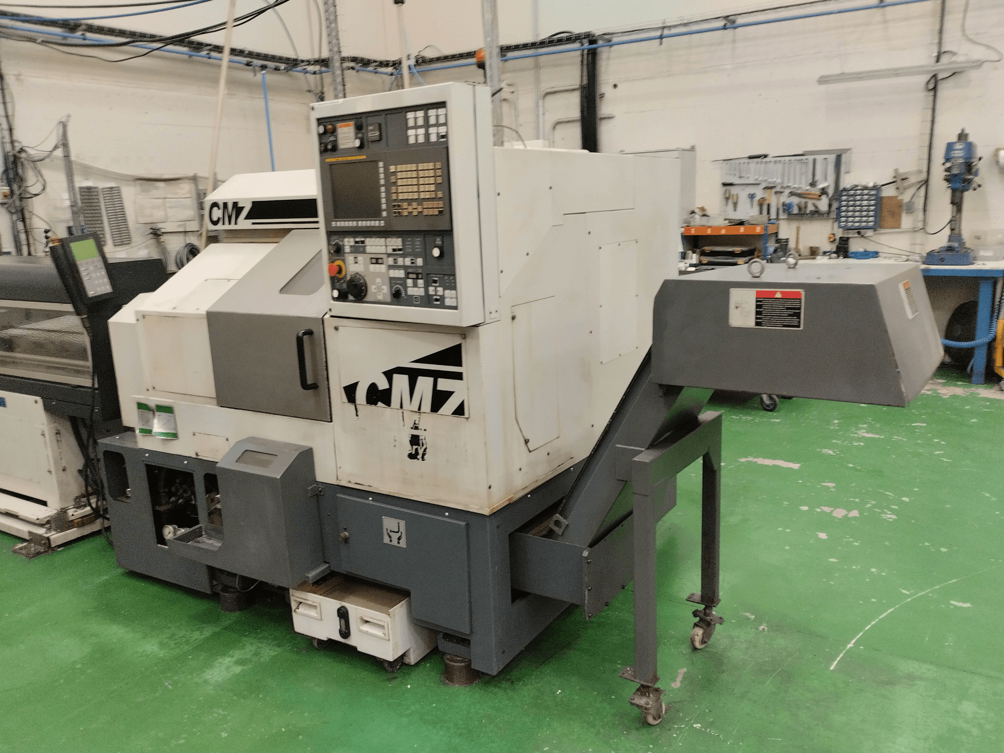 CMZ TB-67M esztergapadozó központ elölnézetben, vezérlőpanellel és adagolószerkezettel, műhelykörnyezetben.