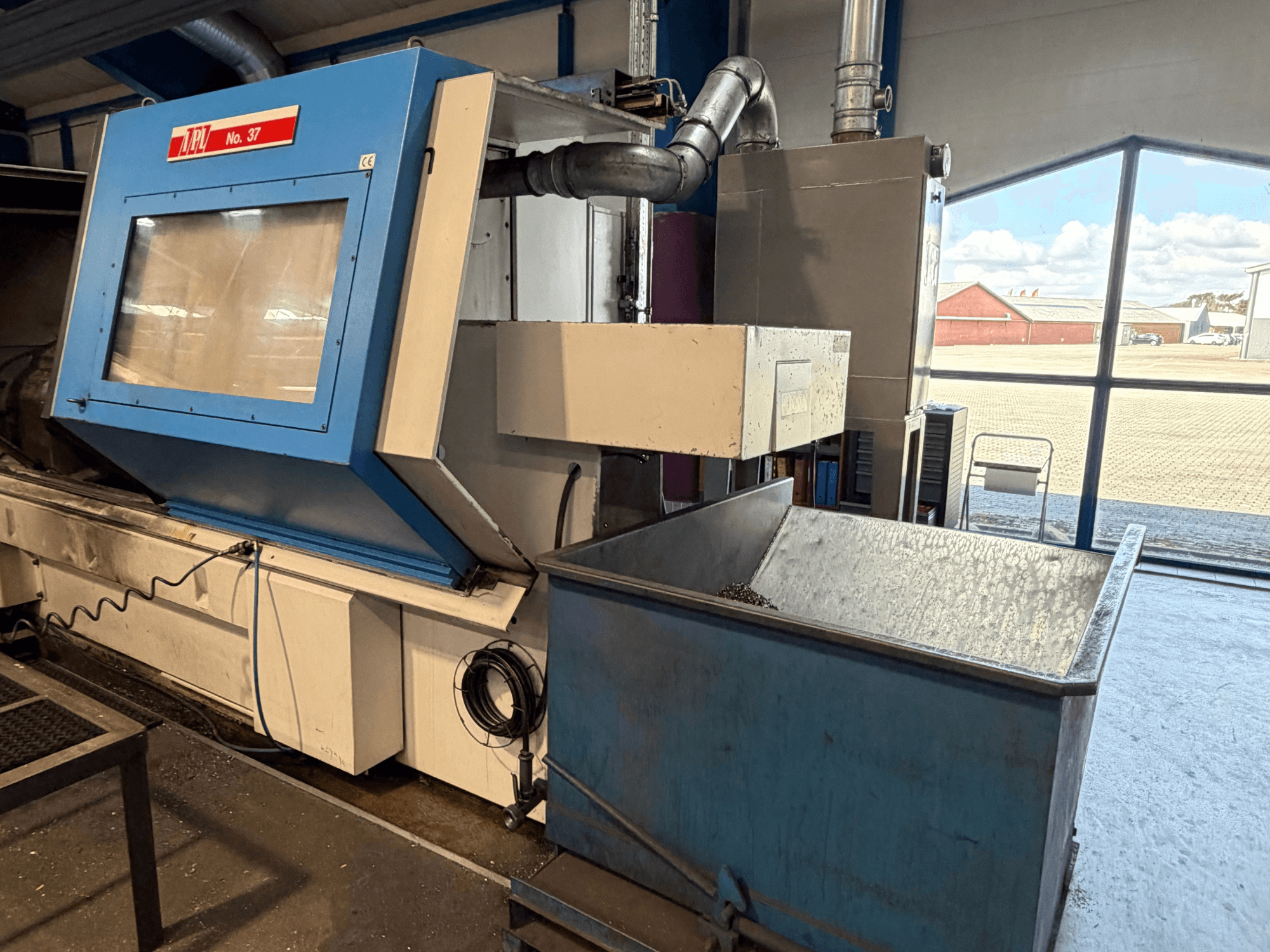 Vízszintes esztergagép BOEHRINGER VDF 315 CM, elölnézetben a kék panel és a hulladékgyűjtő tartály.