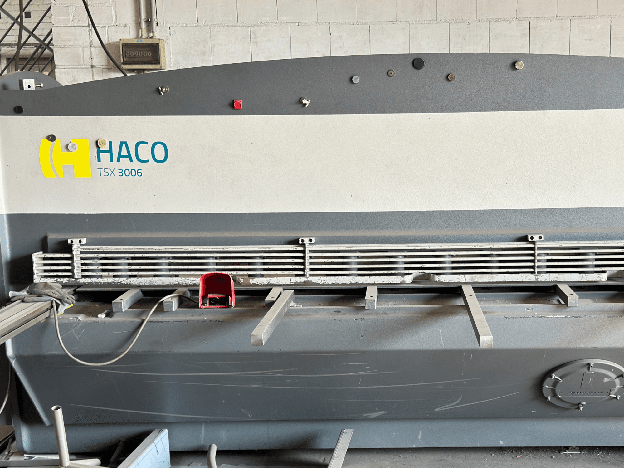 HACO TSX3006 MOT hidraulikus nyírógép, elölnézet, fém vágókésekkel és vezérlőpanellel, működési részletekkel.
