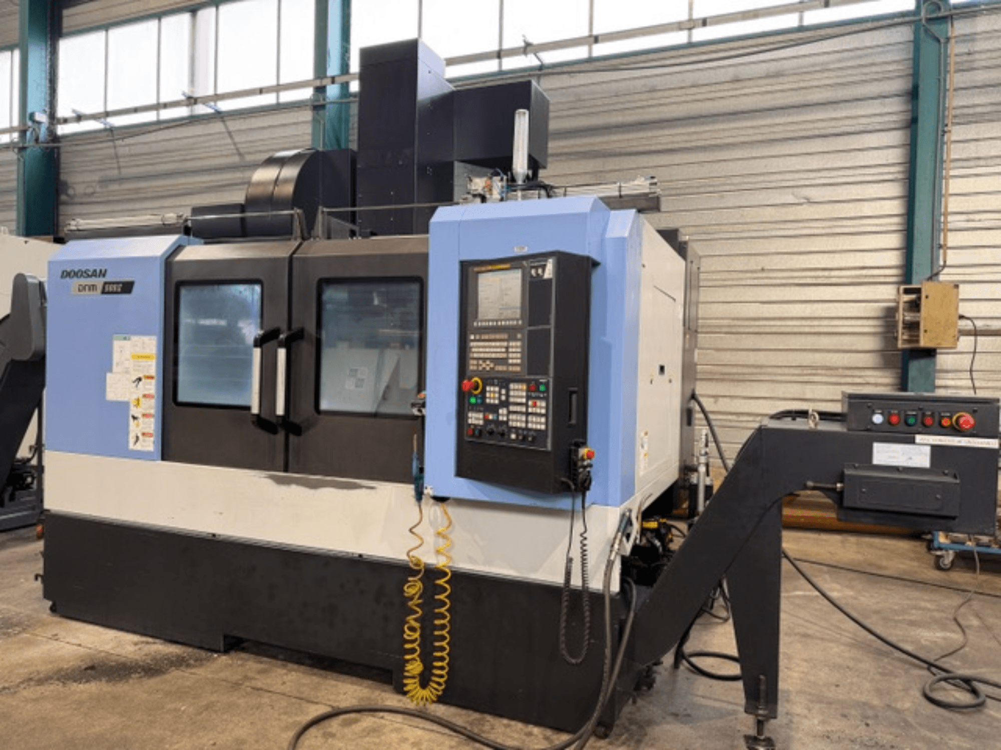 Doosan DNM 500II CNC marógép elölnézetben, vezérlőpanellel és szerszámtartóval, gyári környezetben.
