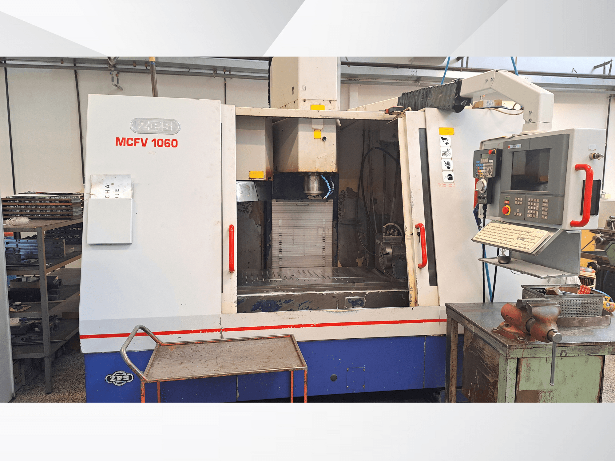 ZPS MCFV 1060 CNC-gép egy műhelyben, elölnézetben a vezérlőpanel, az orsó és a munkaterület; metálszürke és kék színek.