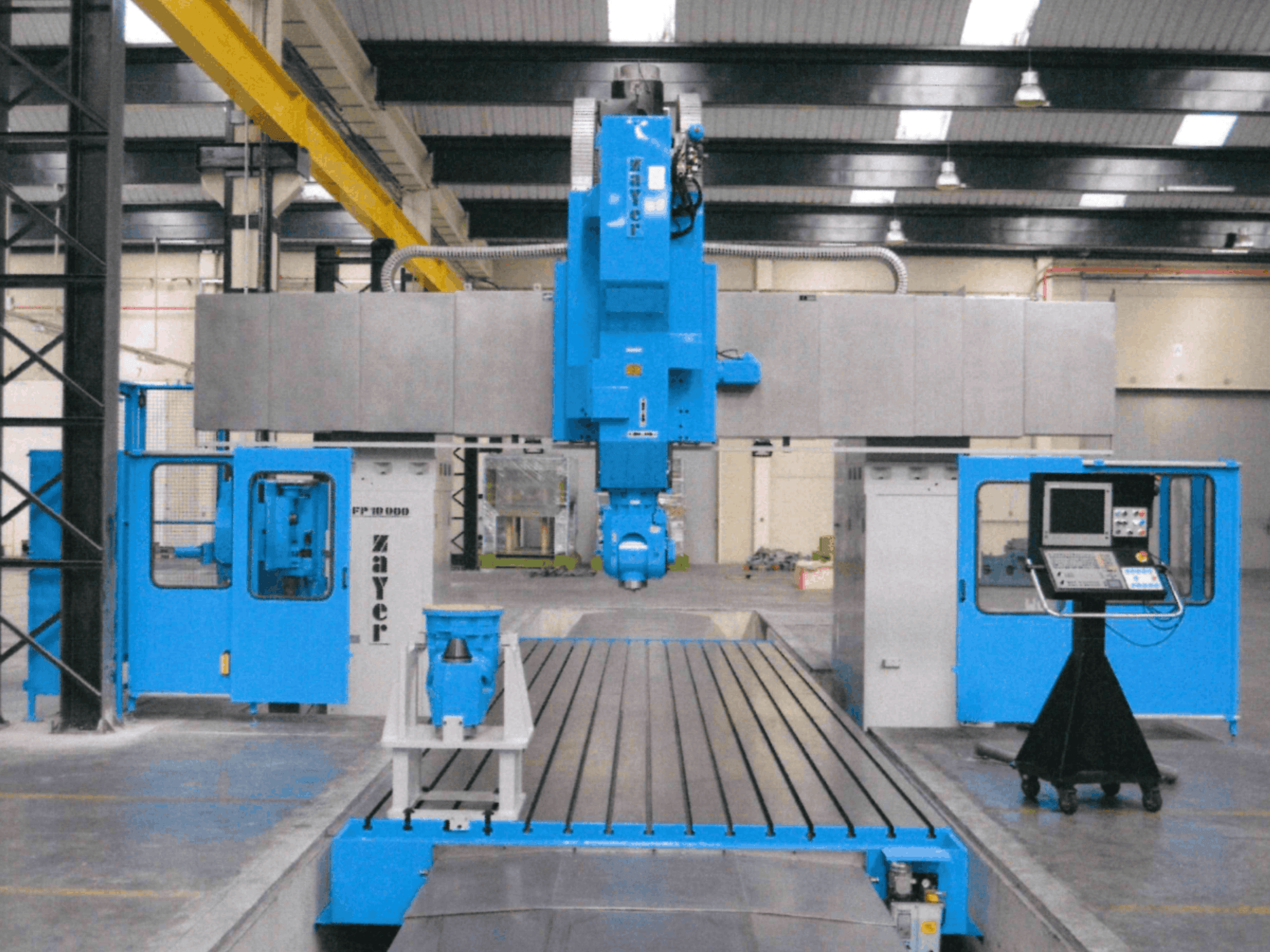 A Zayer FP-10000 ágyas marógép elölnézete, amelyen jól látható a kék váz, a vezérlőpanel és a precíziós alkatrészek.
