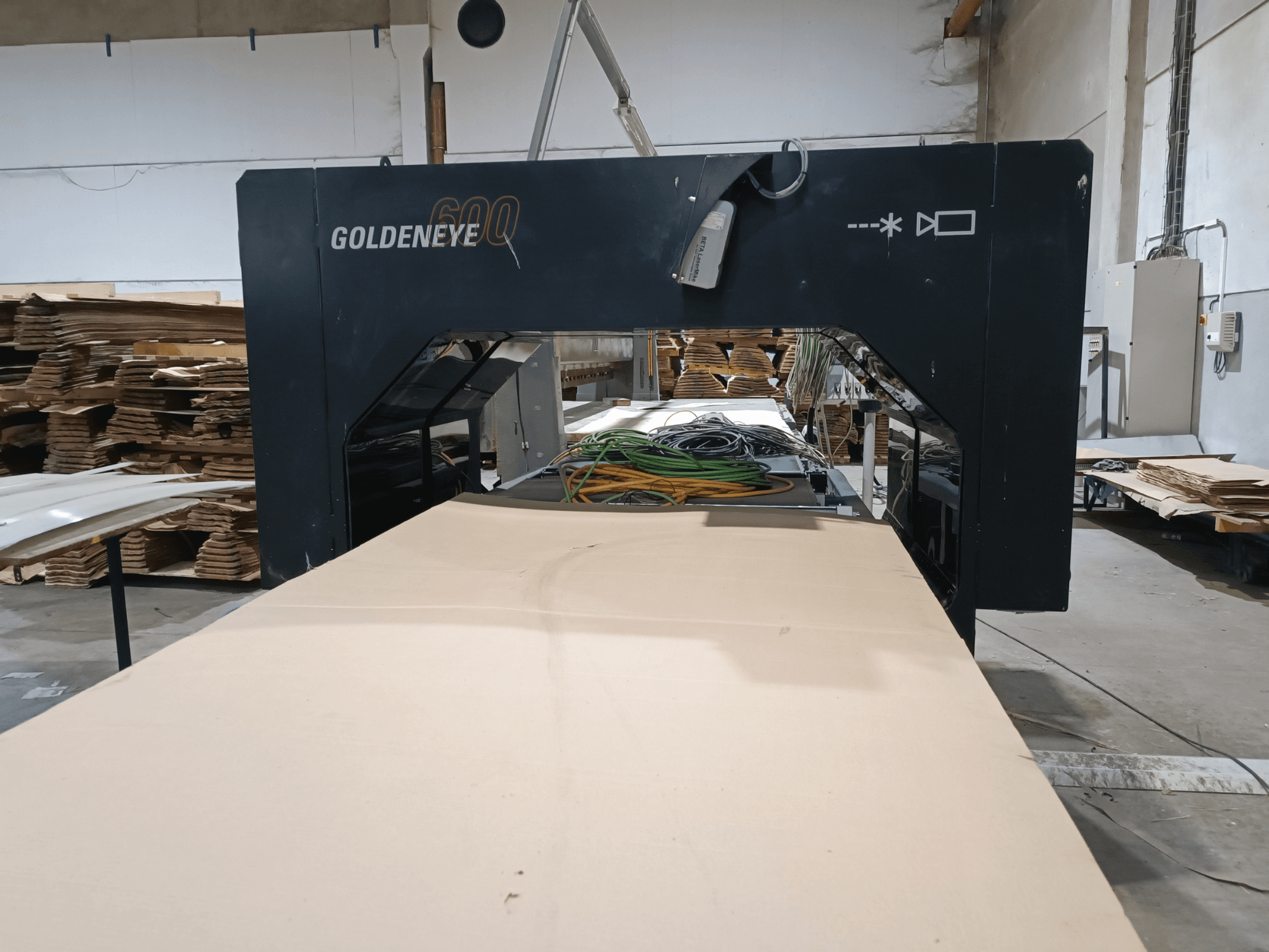 Microtec GOLDENEYE GLD 600 DSC fafeldolgozó gép elölnézetben, nagy vágási felülettel és felszereléssel műhelyben.