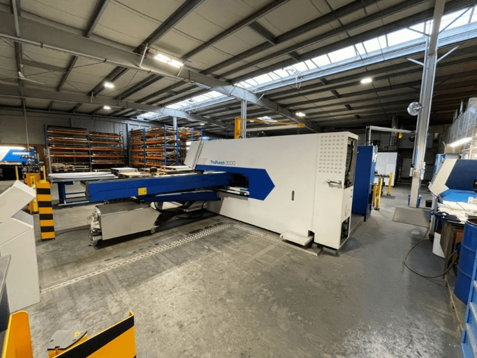 A TRUMPF TruPunch 3000 CNC-lyukasztógép gyári környezetben, elölnézetből: a képen látható a kék-fehér kialakítása és a működési elemei.