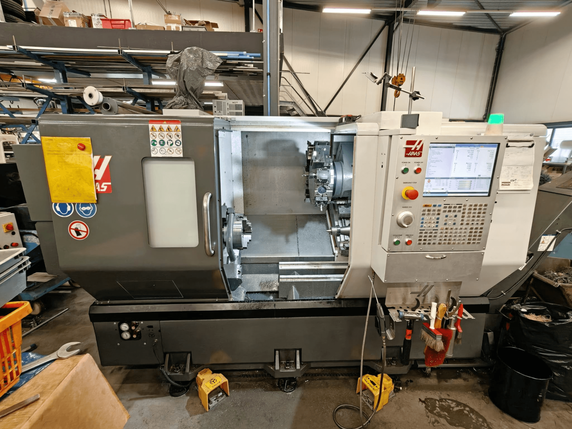 HAAS ST-25Y vízszintes esztergagép, elölnézet, a kezelőpanel, a szerszámtároló és a műhelyben történő üzembe helyezés.