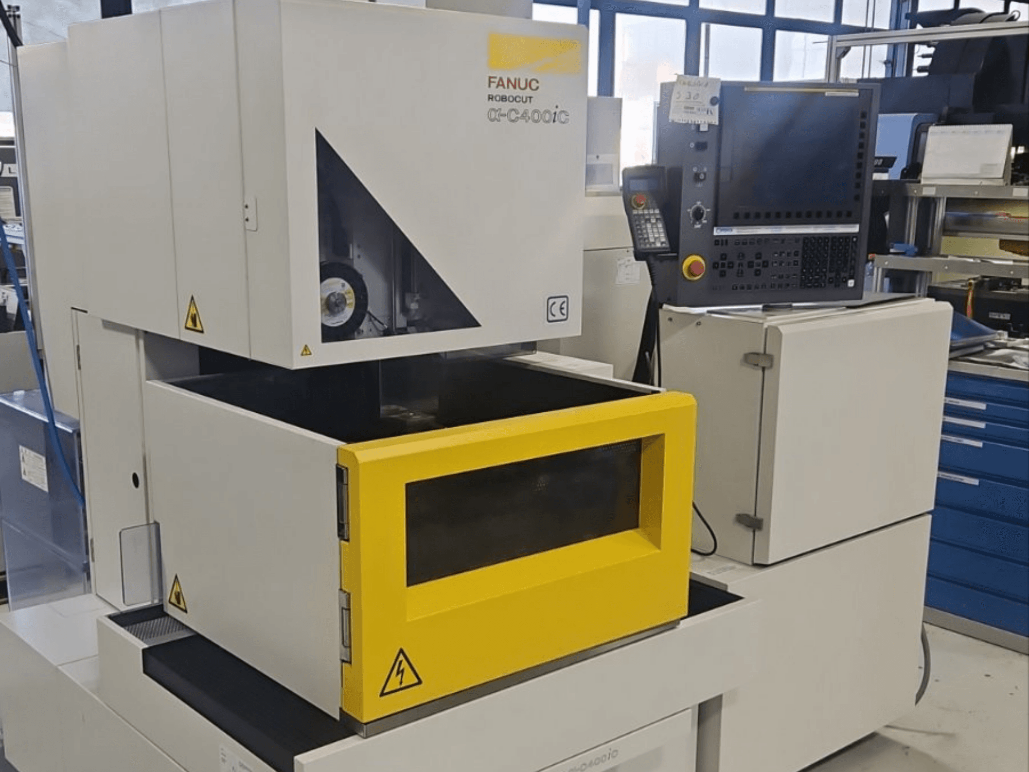 A FANUC Robocut alpha-C400iC mélymetsző szikraforgácsoló gép elölnézetben, sárga munkadarab-kamrával és vezérlőpanellel.