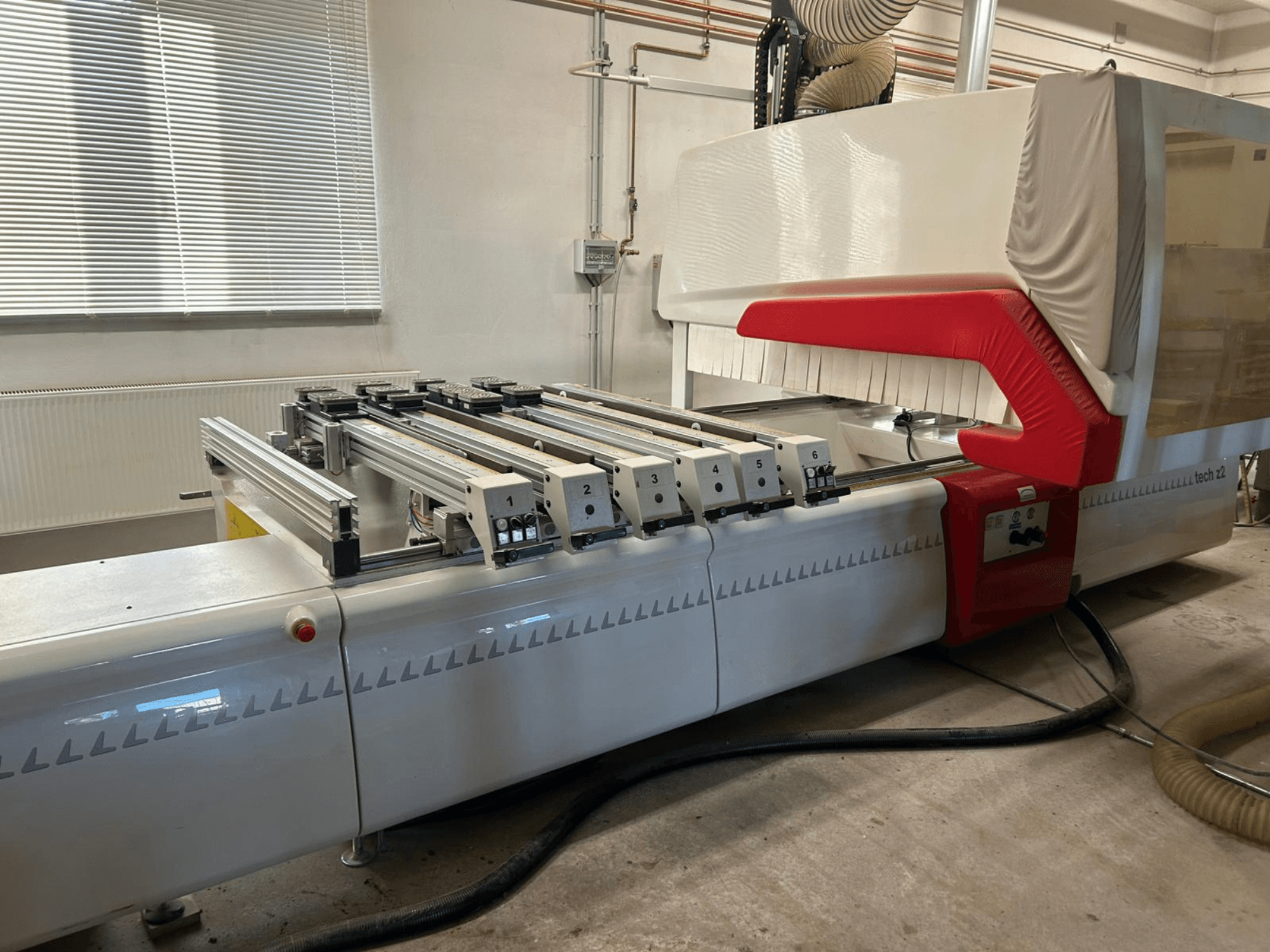 SCM TECH Z2-27-C fafúrógép, oldalnézet, a vezérlőpanel és a sínek, piros-fehér dizájnelemekkel.