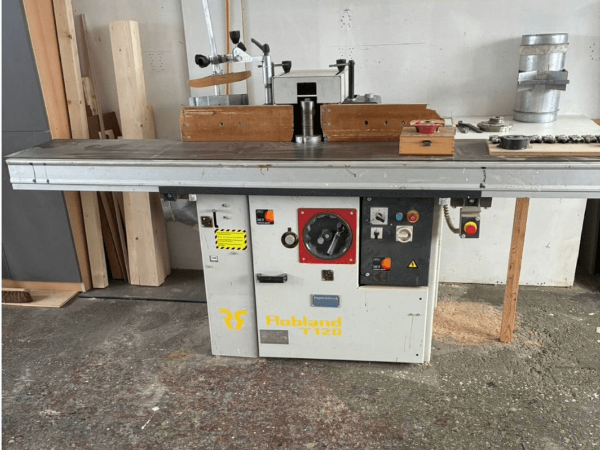 Hobbland T120 asztali gyalugép, előlnézet, ezüstszínű felülettel, gombokkal ellátott kezelőpanellel és biztonsági címkékkel.